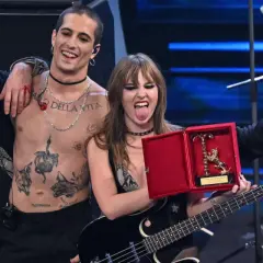 I Måneskin sciolti festeggiano con un premio, Damiano con il torace nudo e tatuato, Victoria con la lingua fuori, Thomas e Ethan con i capelli sciolti.