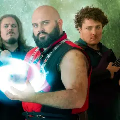 Cinque musicisti con abiti fantasy, uno con una sfera di energia blu, pronti a far sì che il killer venga ucciso.