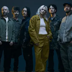 Sei membri di una band posano in abiti casual. L'atmosfera ricorda il genere Linkin Park, con un mix di grinta e stile.