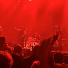Concerto infuocato, la band sul palco, un chitarrista con i capelli lunghi, il batterista, il pubblico esulta. "Kata ton daimona eaytoy" risuona nell'aria.