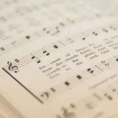 Spartito musicale con simboli musicali e testo. Le note e le parole si fondono in un'armonia visiva.