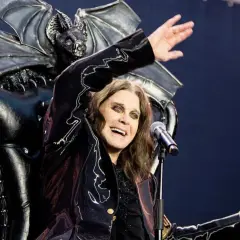 Ozzy Osbourne, icona degli anni '80, canta sul palco con un microfono, dietro di lui un trono demoniaco con ali di pipistrello.