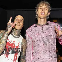Travis Barker e Machine Gun Kelly, co-compositori, posano con le mani alzate in segno di pace e corna.