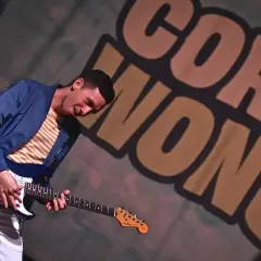 Cory Wong, chitarrista energico, suona la sua Fender con passione. Sullo sfondo, il suo nome in grandi lettere.