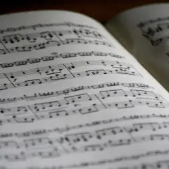 Spartito musicale aperto con note, diesis e bemolle sul pentagramma. La musica attende di essere suonata.