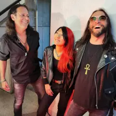 Tre musicisti con look rock, ispirati alle canzoni dei Guns N' Roses Chinese Democracy, sorridono e ridono.