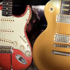 Iconiche chitarre: una Fender rossa consumata e una Gibson dorata, pronte per un duello musicale.