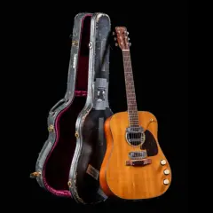 La chitarra acustica di Kurt Cobain, con la sua custodia vissuta, pronta per nuove melodie.