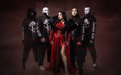 I membri dei Lacuna Coil, con la cantante in abito rosso, posano in un'atmosfera dark.