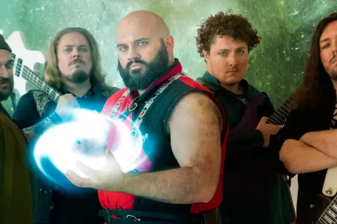 Cinque musicisti con abiti fantasy, uno con una sfera di energia blu, pronti a far sì che il killer venga ucciso.