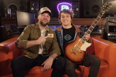 Mancuso chitarrista con un amico in studio, circondati da attrezzature musicali.