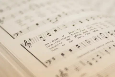Spartito musicale con simboli musicali e testo. Le note e le parole si fondono in un'armonia visiva.