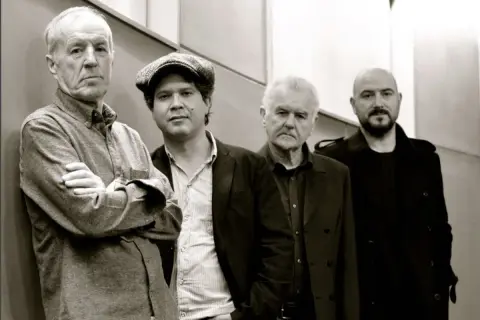 I membri di The Animals, un gruppo di musicisti con un'aria pensierosa, posano in un ritratto in bianco e nero.