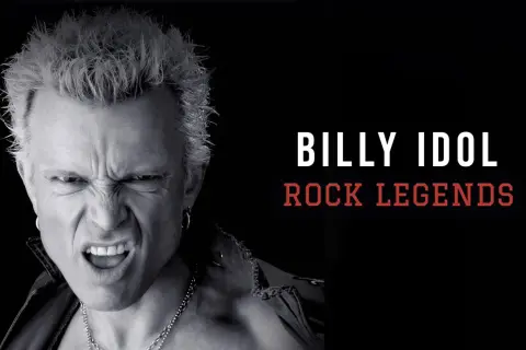 Billy Idol giovane, icona del rock, con espressione grintosa e capelli biondi spettinati.