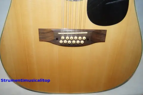 Chitarra acustica a 12 corde con ponte in legno scuro e materiale corde chitarra acustica in primo piano.