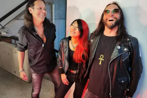 Tre musicisti con look rock, ispirati alle canzoni dei Guns N' Roses Chinese Democracy, sorridono e ridono.
