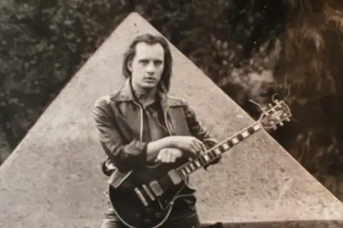 Giovane Richard Benson con la sua chitarra, un'icona rock che non dimenticheremo mai, anche se richard benson morto.