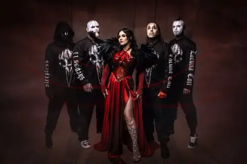 I membri dei Lacuna Coil, con la cantante in abito rosso, posano in un'atmosfera dark.
