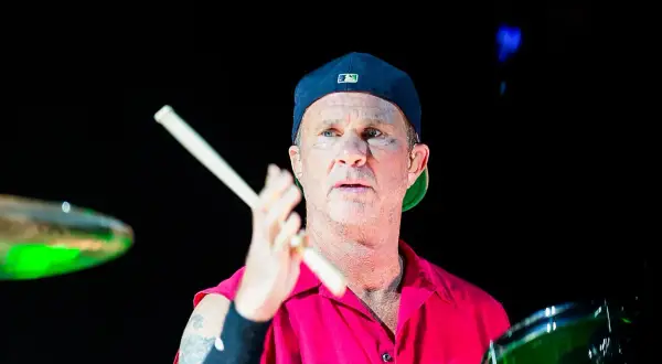 Chad Smith, batterista dei Red Hot Chili Peppers, con bacchette in mano, pronto a colpire la batteria.