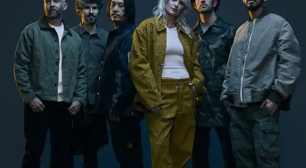 Sei membri di una band posano in abiti casual. L'atmosfera ricorda il genere Linkin Park, con un mix di grinta e stile.