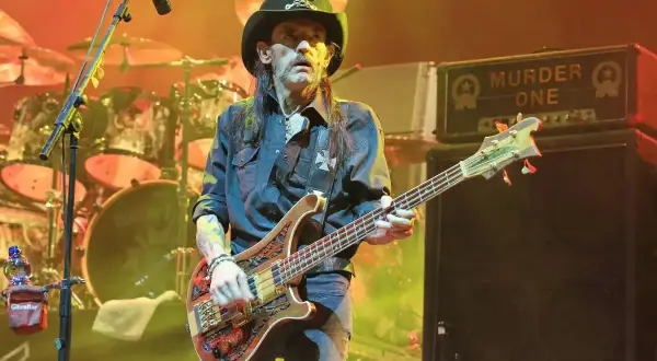 Lemmy Kilmister, icona rock, suona il basso sul palco con il suo inconfondibile cappello.