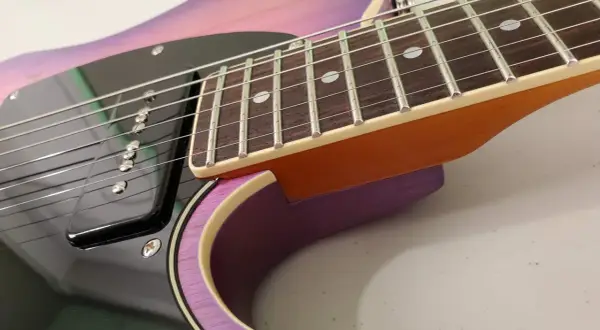 Dettaglio della chitarra Schecter PT Special con finitura sfumata viola e rosa, tastiera in palissandro e pickup nero.