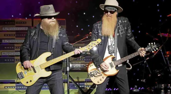 Due musicisti con lunghe barbe e cappelli suonano sul palco. Uno suona un basso giallo, l'altro una chitarra. È più facile suonare il basso o la chitarra?