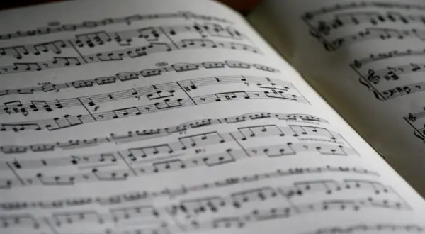 Spartito musicale aperto con note, diesis e bemolle sul pentagramma. La musica attende di essere suonata.
