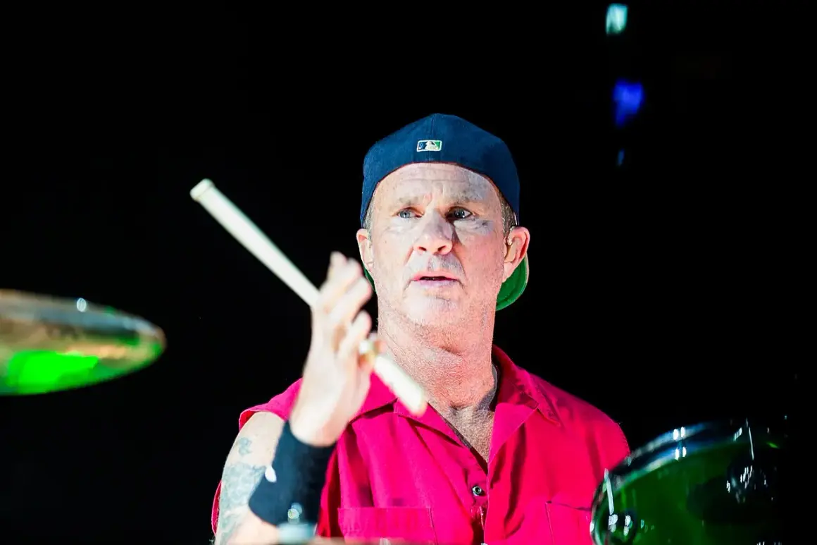 Chad Smith, batterista dei Red Hot Chili Peppers, con bacchette in mano, pronto a colpire la batteria.