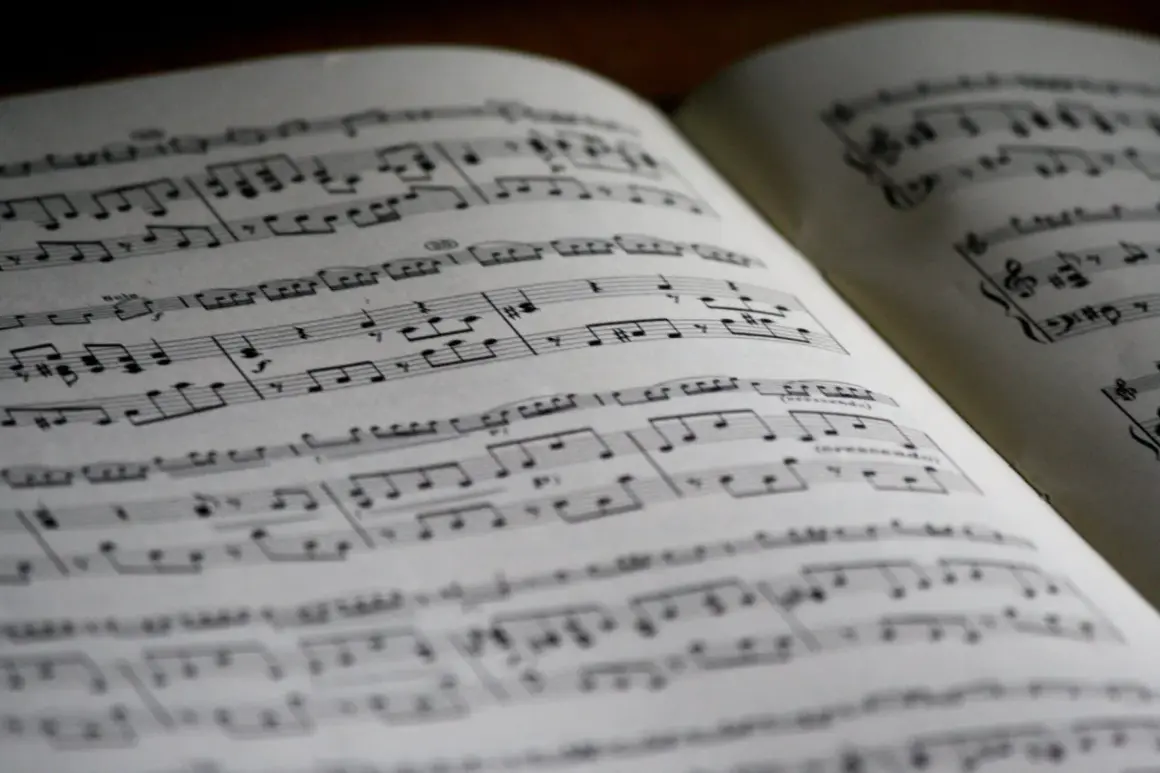 Spartito musicale aperto con note, diesis e bemolle sul pentagramma. La musica attende di essere suonata.