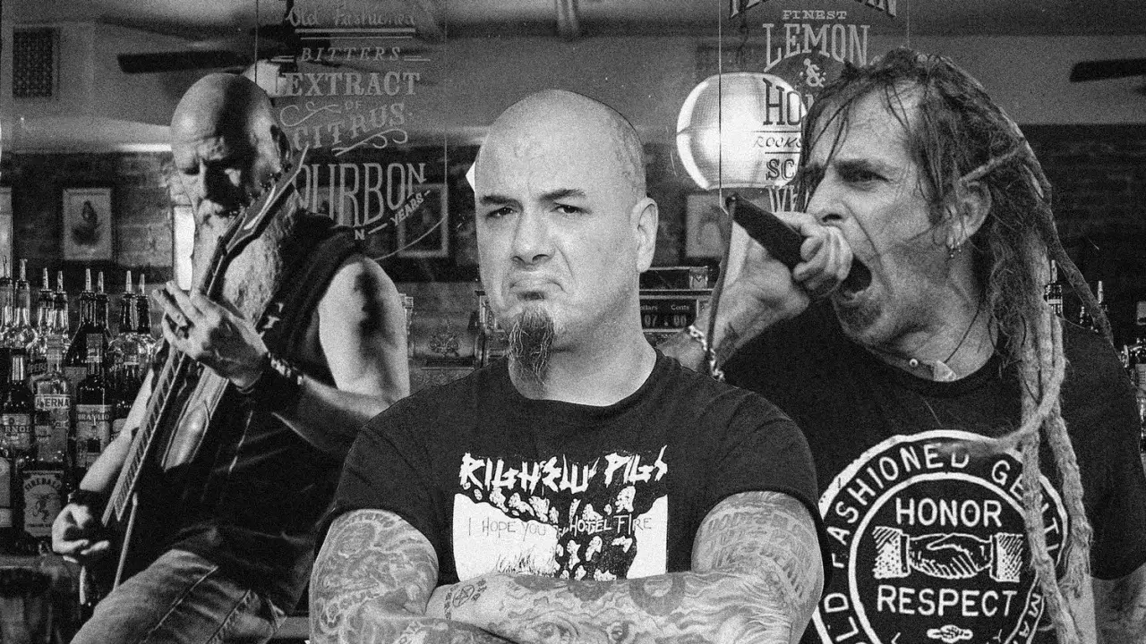 Tre musicisti metal creano la base ritmica di un brano, con un chitarrista, un cantante e un altro membro con le braccia incrociate.
