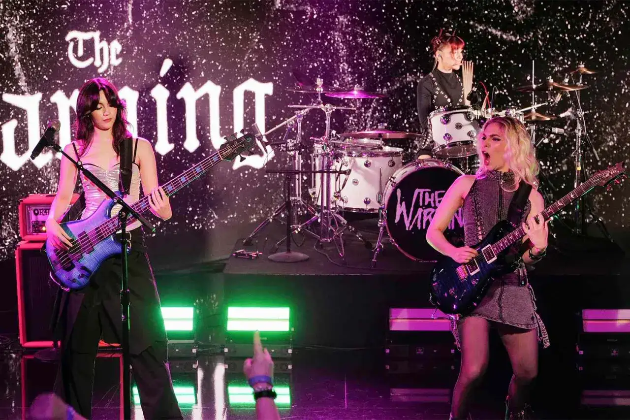 Membri di The Warning sul palco, con la bassista a sinistra, la chitarrista a destra e la batterista sullo sfondo.
