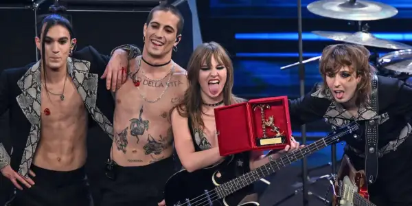 I Måneskin sciolti festeggiano con un premio, Damiano con il torace nudo e tatuato, Victoria con la lingua fuori, Thomas e Ethan con i capelli sciolti.