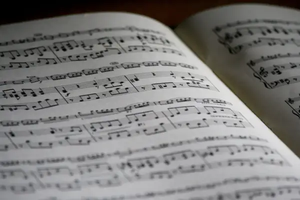 Spartito musicale aperto con note, diesis e bemolle sul pentagramma. La musica attende di essere suonata.