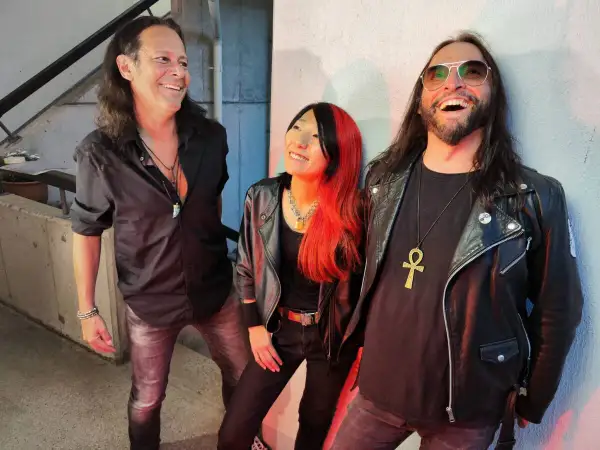 Tre musicisti con look rock, ispirati alle canzoni dei Guns N' Roses Chinese Democracy, sorridono e ridono.
