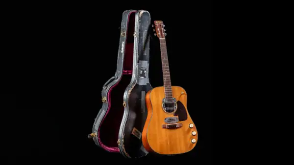 La chitarra acustica di Kurt Cobain, con la sua custodia vissuta, pronta per nuove melodie.