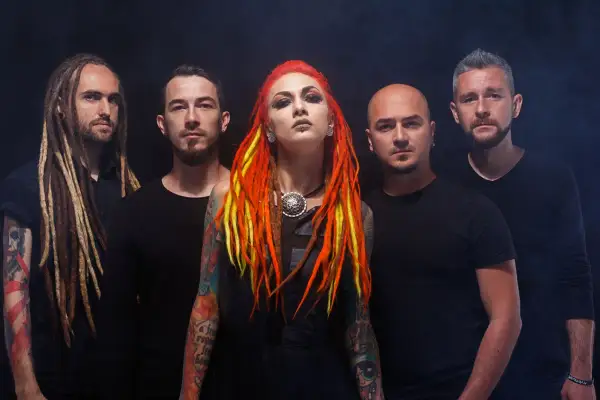 La band "Infected Rain" posa con look aggressivo. La cantante ha capelli rosso-giallo e tatuaggi colorati.